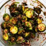 Chopped cucumbers marinated with Korean spices and sesame seeds in a bowl.