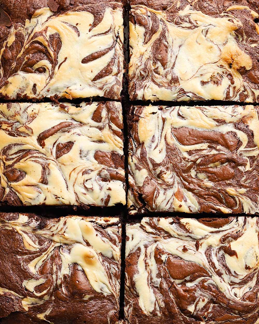 Six cheesecake swirl brownies with a marble-like pattern.