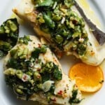 Halibut with green olive salsa verde and a slice of citrus.