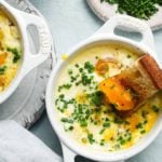 Baked eggs in a dish with chives and toasted bread.