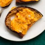 Toasted bread slice topped with creamy butternut squash spread and seasoning.
