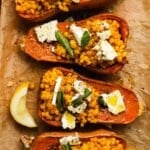 Stuffed honeynut squash with couscous, feta, fresh herbs, and a lemon wedge.