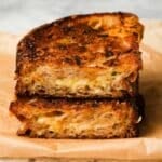 Toasted garlic bread grilled cheese with melted cheese on parchment paper.