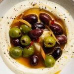 Assorted olives on whipped ricotta, garnished with citrus zest and cracked pepper.