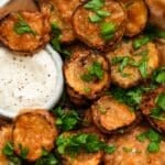 Golden fried pickles with fresh herbs and creamy dipping sauce.