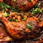 Braised chicken with gochujang, chickpeas, sesame seeds, and green onions in sauce.