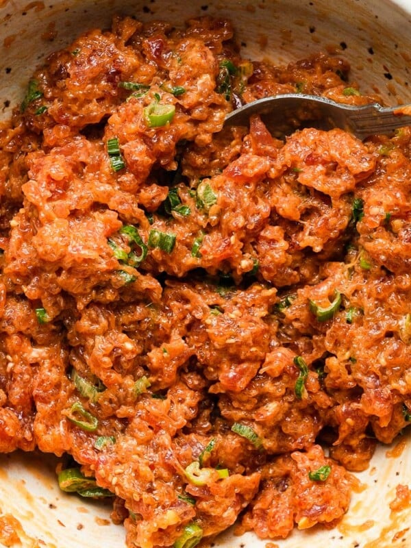 Spicy tuna with green onions in a bowl, mixed with a fork.