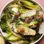 Grilled Little Gem lettuce Caesar salad with croutons and grated cheese.