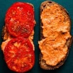 Slices of tomato with mayo on dark bread.