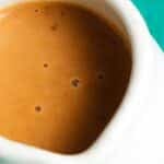 Rich, brown garlic rosemary gravy in a white pitcher.