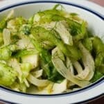 A fresh fennel salad with shaved celery, garnished with dill and black pepper.