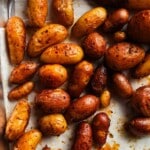 Golden roasted baby potatoes with paprika seasoning on a baking sheet.