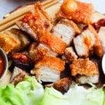 Crispy pork belly served with lettuce and a spicy dipping sauce.