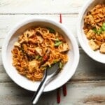 Bowls of spicy Mapo Tofu Ramen with mushrooms and green onions on wooden table.