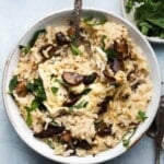 Creamy mushroom risotto garnished with fresh parsley in a white bowl.