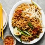 Plate of Tofu Pad Thai with lime, bean sprouts, and chili flakes.