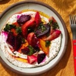 Vibrant roasted beet salad with labneh, herbs, and a fork on the side.