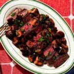 Steak and balsamic glazed mushrooms plated with a fork.