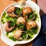 Escargot shells filled with fragrant herb butter, served alongside fresh crusty bread.