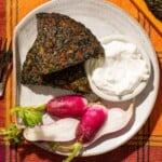 Two slices of Kuku Sabzi with radishes and yogurt on a plate.