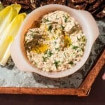 Herb-topped smoked trout dip with olive oil served with endive and seeded crackers.