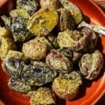 A bowl filled with potato salad with Chimichurri mayo with a spoon in it.