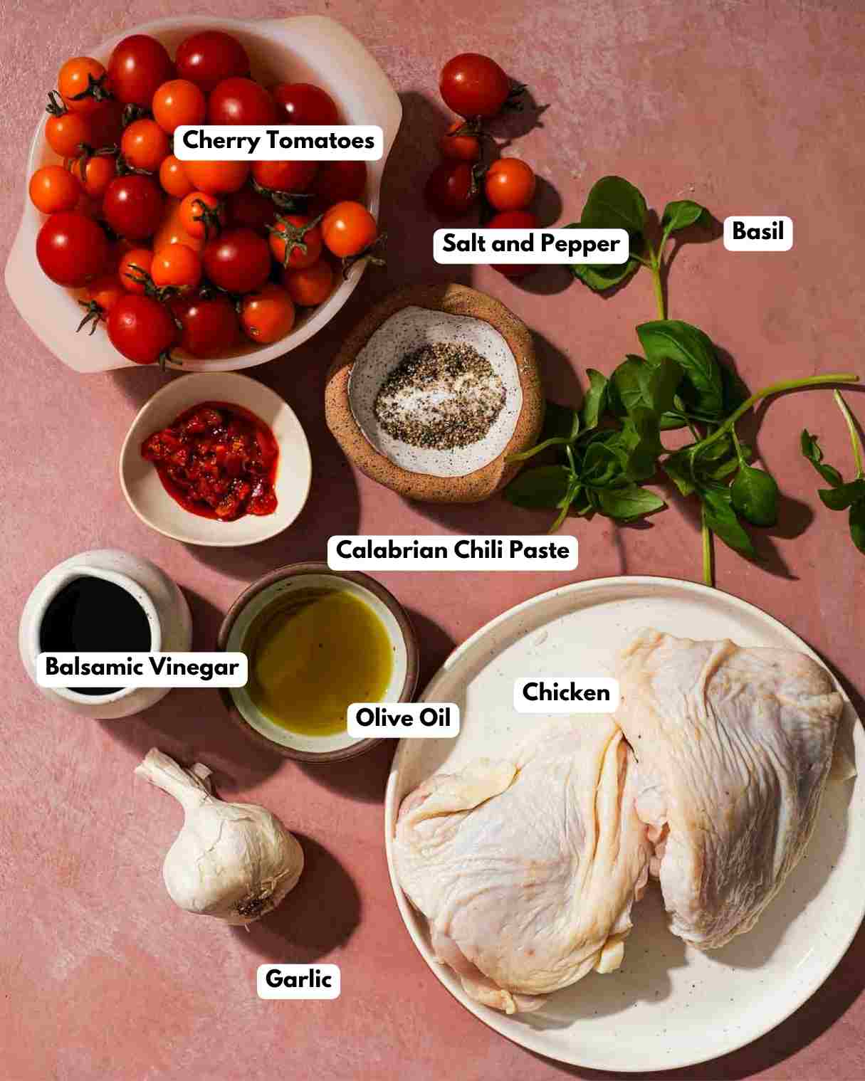All the ingredients on a table to make balsamic chicken and tomatoes.