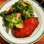 Crispy buffalo chicken cutlet served with romaine and tomato salad.
