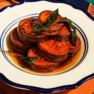 A plate of fondant sweet potatoes with sage and flaky salt.