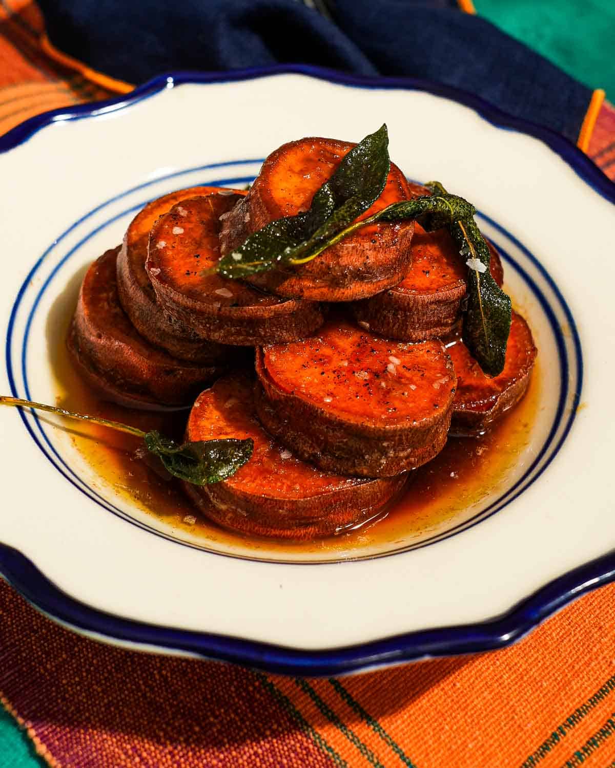 A plate of fondant sweet potatoes with sage and flaky salt.