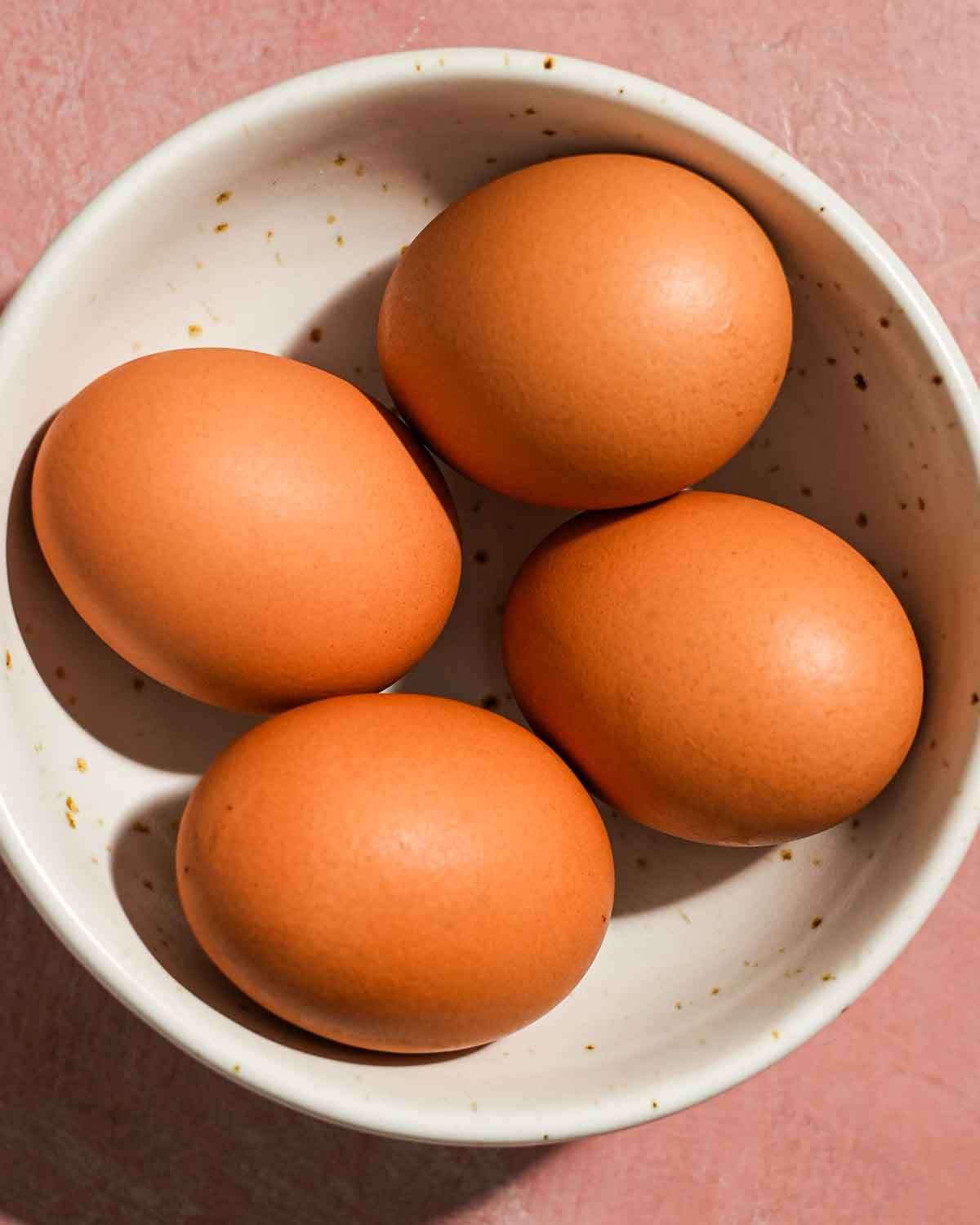 Soft boiled eggs in a boil ready to be peeled for tuna nicoise salad.