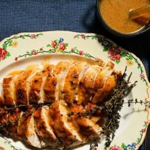 A platter of sliced chicken breast with chicken gravy.