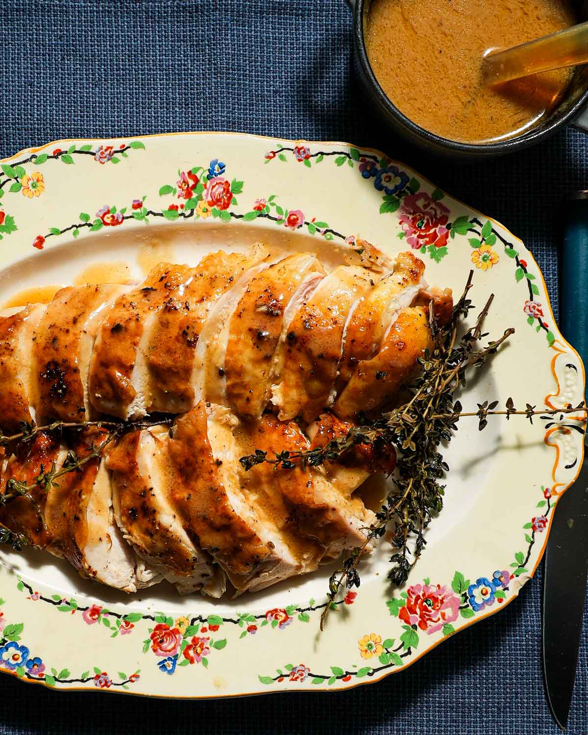 A platter of sliced chicken breast with chicken gravy.