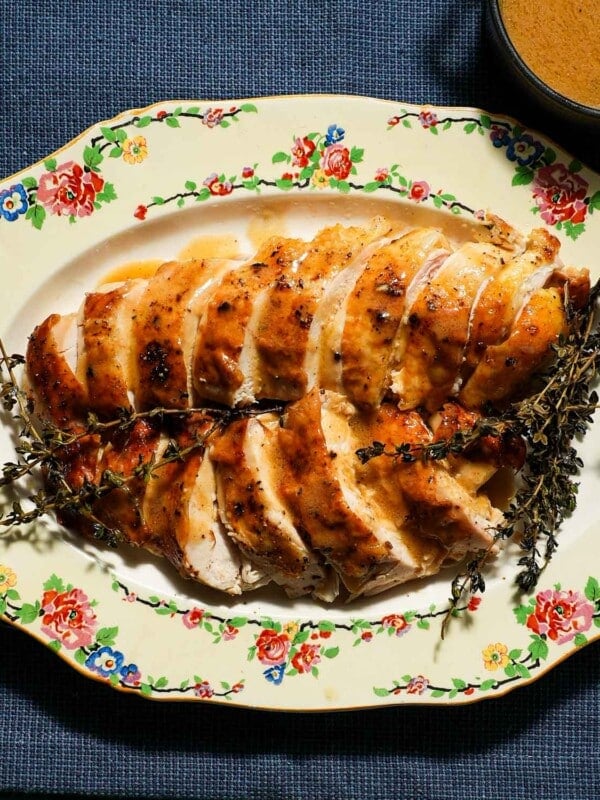 A platter of sliced chicken breast with chicken gravy.