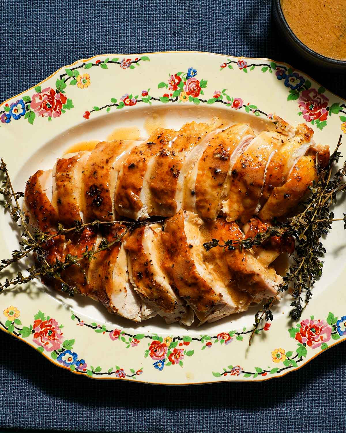 A platter of sliced chicken breast with chicken gravy.