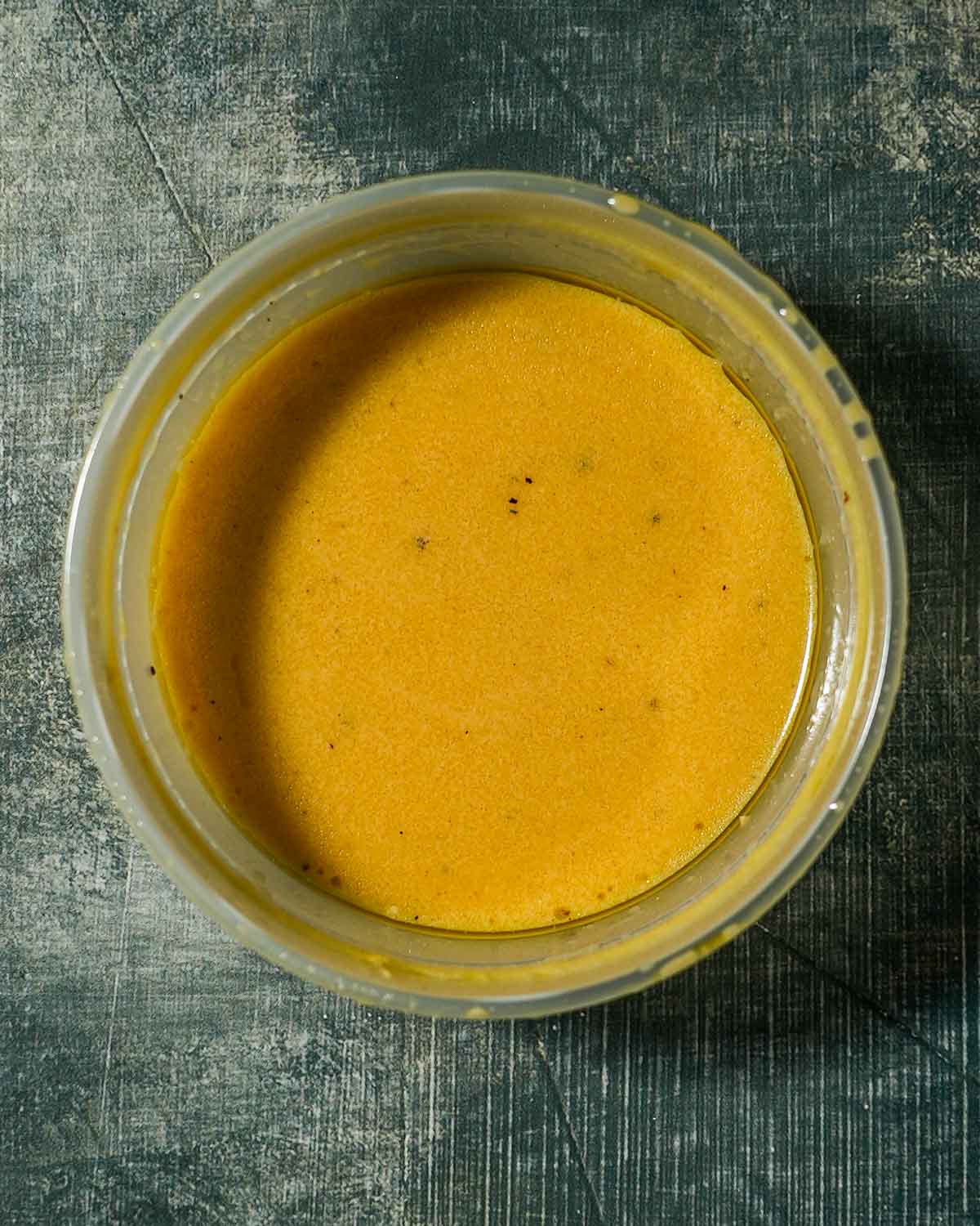 A deli container of cara cara orange dressing.