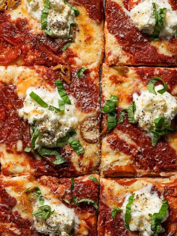 Sheet pan pizza with burrata and hot honey cut into squares.