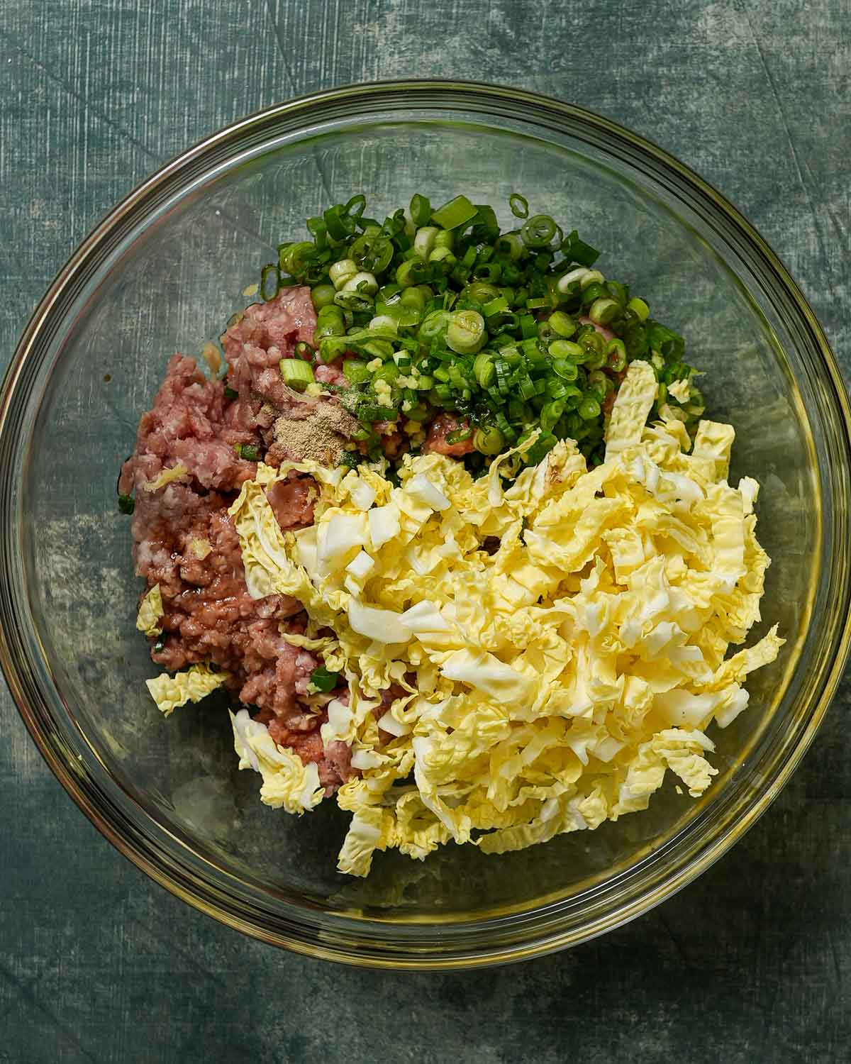 A bowl of dumpling filling about to be tossed for dumpling lasagna.