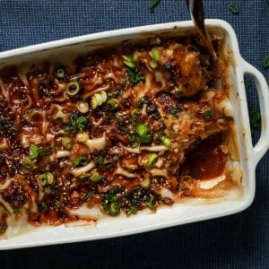 A baking pan of dumpling lasagna with a scooped slice with a spoon.