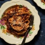 A bowl of braised short rib ragu with tagliatelle with a fork.