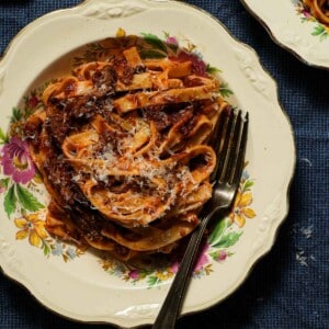A bowl of braised short rib ragu with tagliatelle with a fork.
