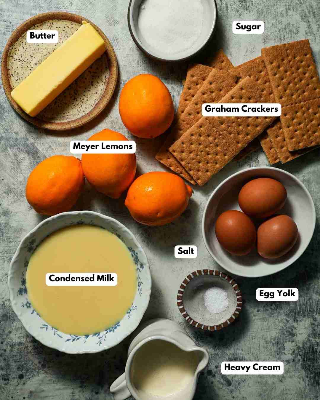 The ingredients laid out to make meyer lemon pie with graham cracker crust.