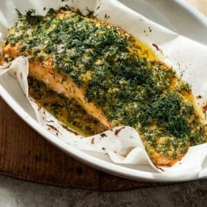 Dijon mustard dill salmon after being cooked in a baking dish with parchment paper.