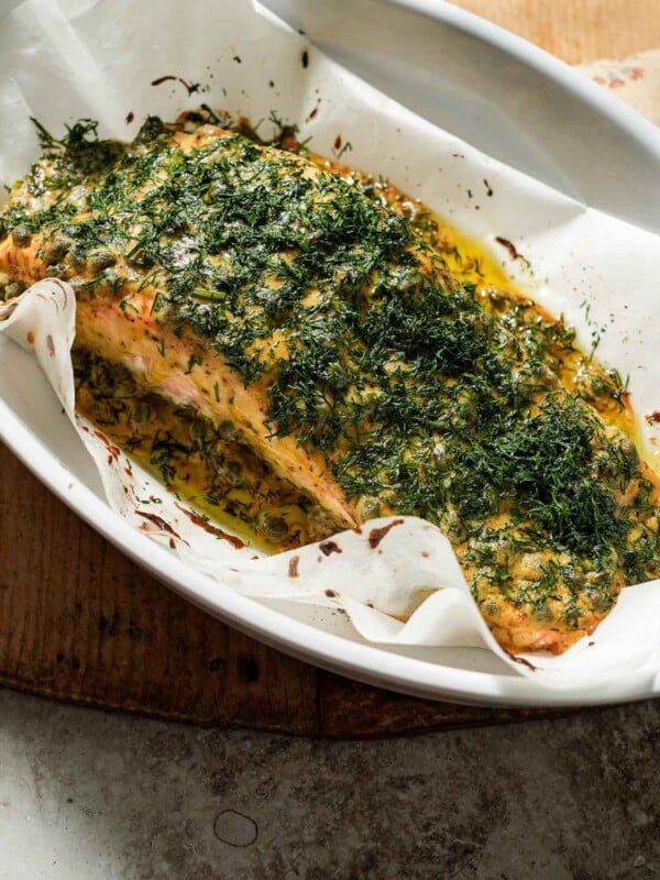 Dijon mustard dill salmon after being cooked in a baking dish with parchment paper.