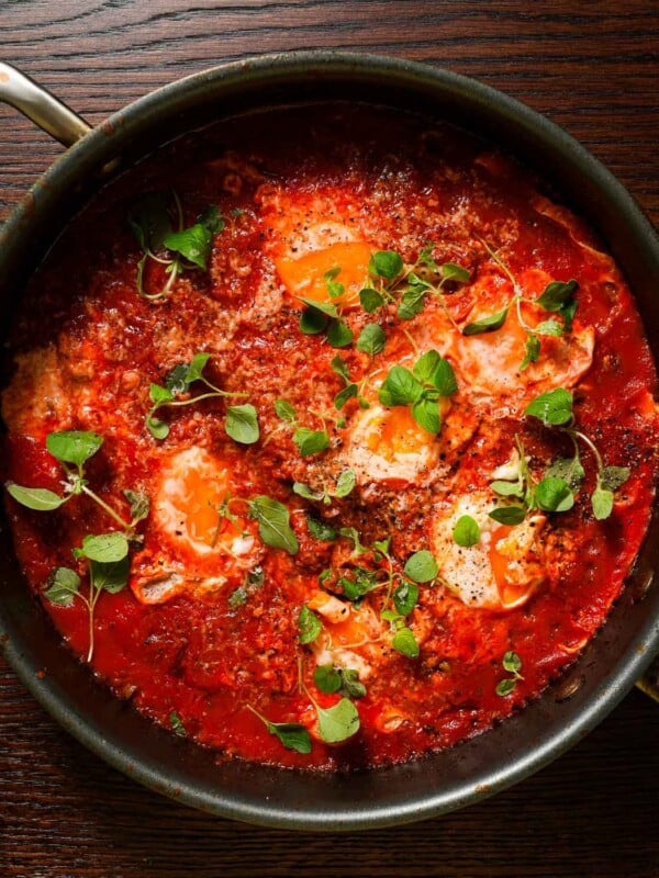 A skillet with spicy tomato sauce stewed with eggs, topped with oregano and parmesan.