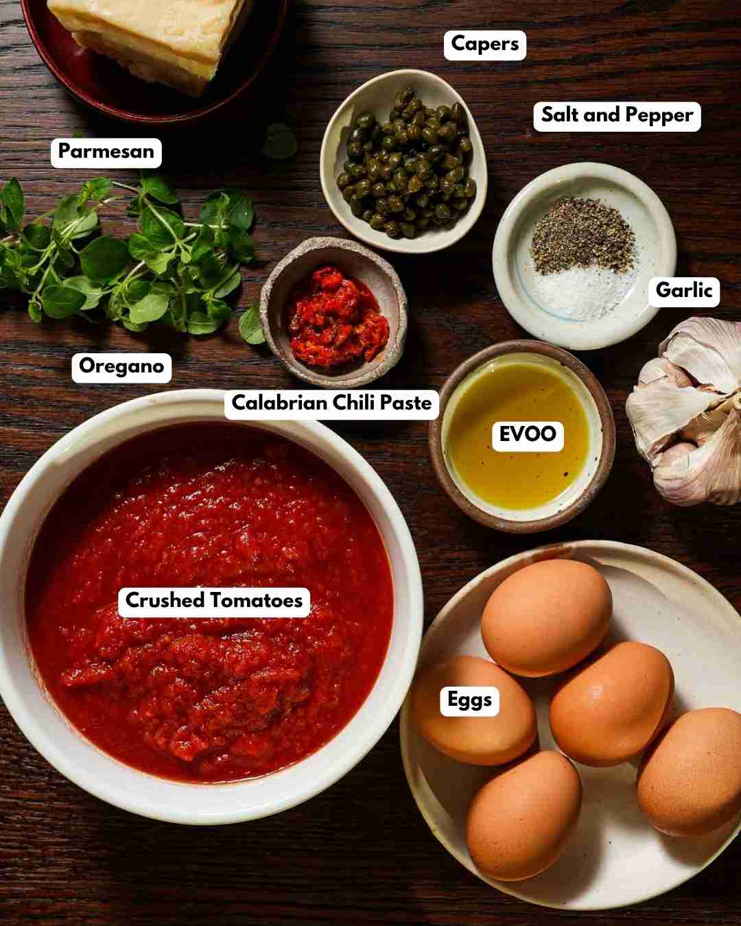 All the ingredients laid out to make eggs in purgatory with capers and Calabrian chili.