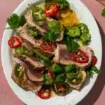 A platter of seared ahi tuna with peppercorns and a yuzu dressing.