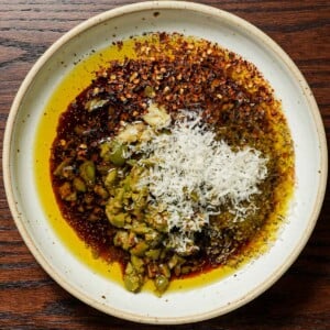 Ingredients in a bowl of bread dipping oil with olives and balsamic vinegar.