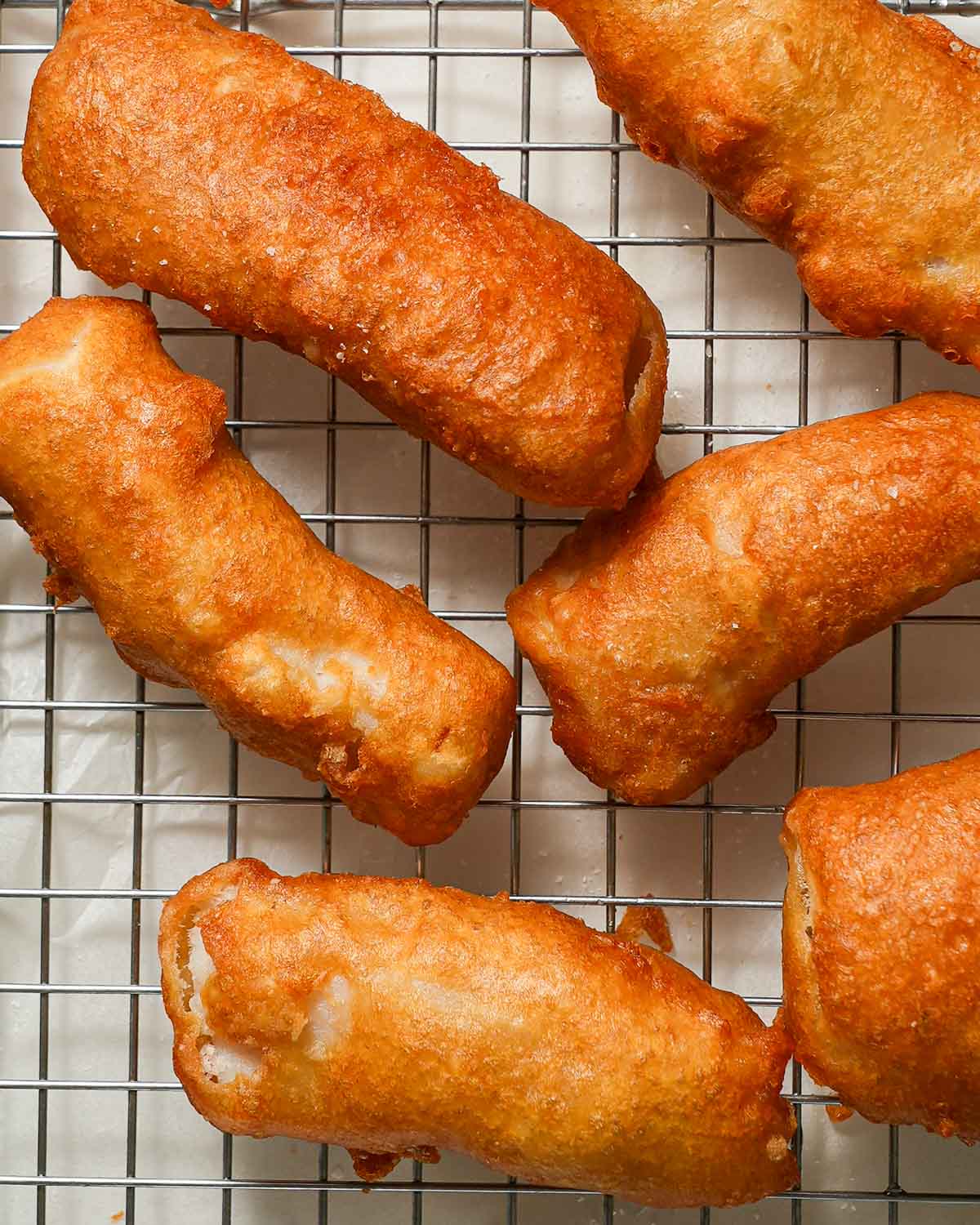Pieces of crispy fish on a drying rack.