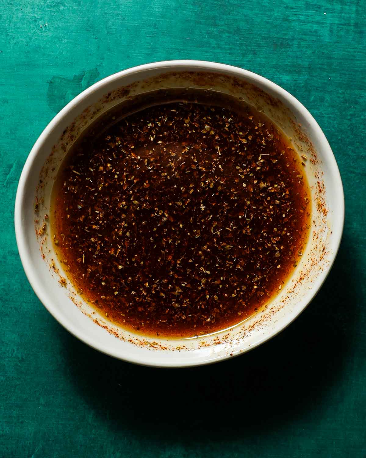 A plate of spices mixed with olive oil ready to be added on chicken.